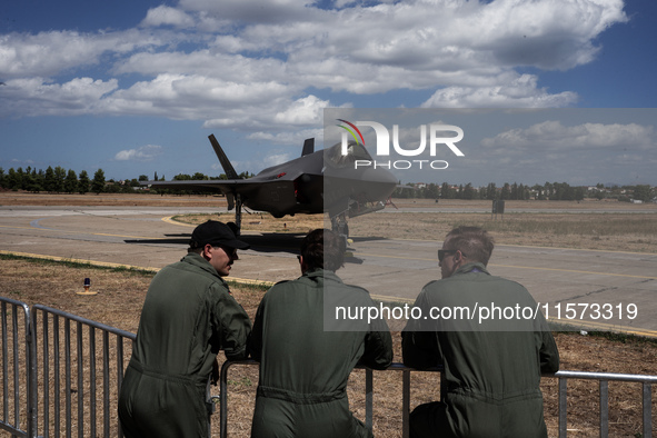 Three pilots look at an aircraft during the Athens Flying Show in Tanagra, Greece, on September 14, 2024. 