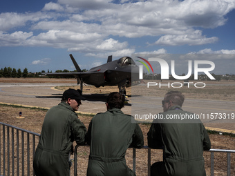 Three pilots look at an aircraft during the Athens Flying Show in Tanagra, Greece, on September 14, 2024. (