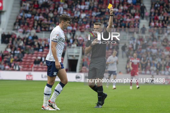 Referee Tom Nield shows Preston North End's Jordan Storey the yellow card during the Sky Bet Championship match between Middlesbrough and Pr...