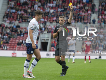 Referee Tom Nield shows Preston North End's Jordan Storey the yellow card during the Sky Bet Championship match between Middlesbrough and Pr...