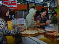 Young people sell Indonesian traditional pancake products (Klepon) at Oro Oro Dowo traditional market in Malang, East Java, Indonesia, on Se...