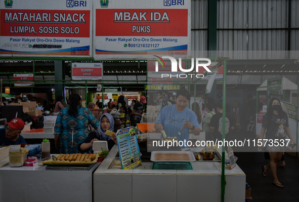 Young people sell Indonesian traditional pancake products (Klepon) at Oro Oro Dowo traditional market in Malang, East Java, Indonesia, on Se...