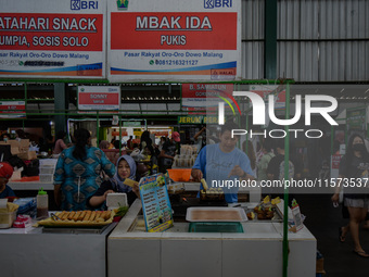 Young people sell Indonesian traditional pancake products (Klepon) at Oro Oro Dowo traditional market in Malang, East Java, Indonesia, on Se...