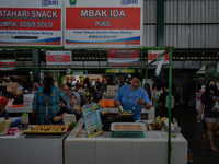 Young people sell Indonesian traditional pancake products (Klepon) at Oro Oro Dowo traditional market in Malang, East Java, Indonesia, on Se...