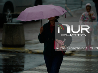 People with umbrellas are seen during a bout of rain in Warsaw, Poland on 14 September, 2024. Warnings for heavy rainfall and severe floodin...