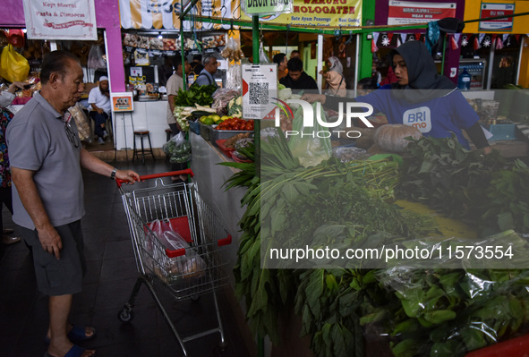 Activities of visitors and vegetable traders at Oro Oro Dowo traditional market in Malang, East Java, Indonesia, on September 14, 2024. This...