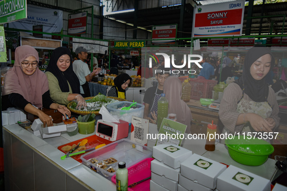 Young people sell Indonesian traditional pancake products (Klepon) at Oro Oro Dowo traditional market in Malang, East Java, Indonesia, on Se...