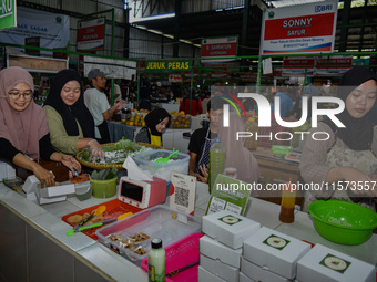 Young people sell Indonesian traditional pancake products (Klepon) at Oro Oro Dowo traditional market in Malang, East Java, Indonesia, on Se...