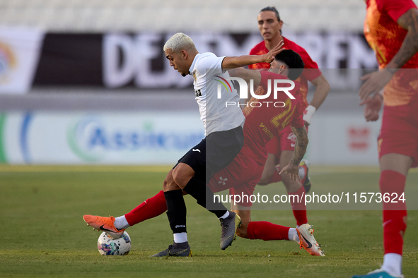 In Ta' Qali, Malta, on September 14, 2024, Kleiton do Monte Lima Basilio of Hibernians is closely challenged by Leandro Lautaro Lacunza of B...