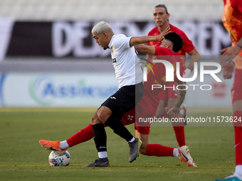 In Ta' Qali, Malta, on September 14, 2024, Kleiton do Monte Lima Basilio of Hibernians is closely challenged by Leandro Lautaro Lacunza of B...