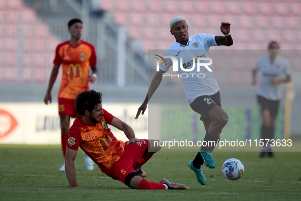 In Ta' Qali, Malta, on September 14, 2024, Alex Bruno de Souza Silva (right) of Hibernians is closely challenged by Augustin Sandona (left)...