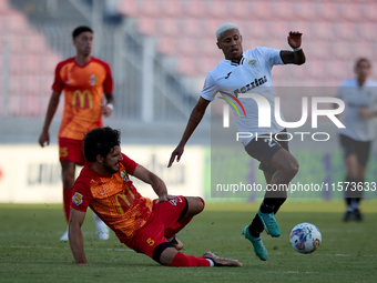 In Ta' Qali, Malta, on September 14, 2024, Alex Bruno de Souza Silva (right) of Hibernians is closely challenged by Augustin Sandona (left)...