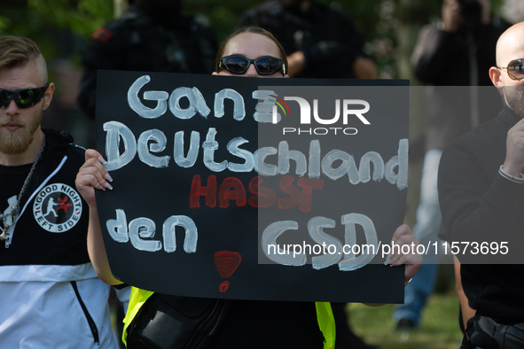 A protester holds a sign reading ''All German Hate CSD'' as dozens of counter-protesters from several right-wing groups organize a demonstra...