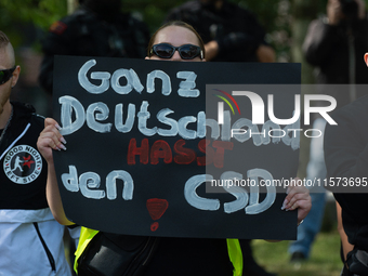 A protester holds a sign reading ''All German Hate CSD'' as dozens of counter-protesters from several right-wing groups organize a demonstra...