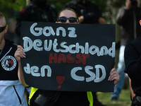 A protester holds a sign reading ''All German Hate CSD'' as dozens of counter-protesters from several right-wing groups organize a demonstra...