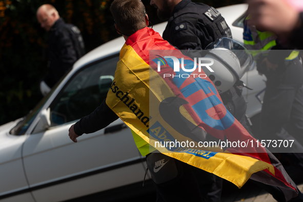 A protester with an AFD flag is seen as dozens of counter-protesters from several right-wing groups organize a demonstration against the ann...