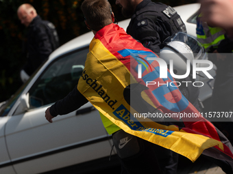 A protester with an AFD flag is seen as dozens of counter-protesters from several right-wing groups organize a demonstration against the ann...