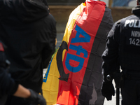 A protester with an AFD flag is seen as dozens of counter-protesters from several right-wing groups organize a demonstration against the ann...