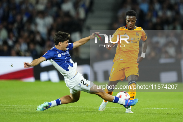 Vinicius Junior left winger of Real Madrid and Brazil and Aramburu of Real Sociedad and Spain controls the ball o during the La Liga match b...