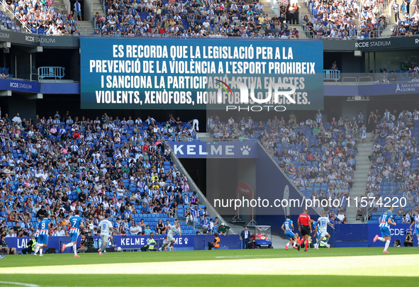 A warning on the scoreboard advises against chanting racist, homophobic, or xenophobic insults or engaging in violent actions in the stands...