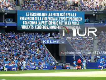 A warning on the scoreboard advises against chanting racist, homophobic, or xenophobic insults or engaging in violent actions in the stands...