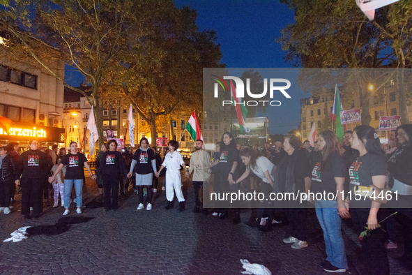 Nearly a hundred Iranian activists take part in a candlelight vigil for the second anniversary of Mahsa Amini's death in Cologne, Germany, o...