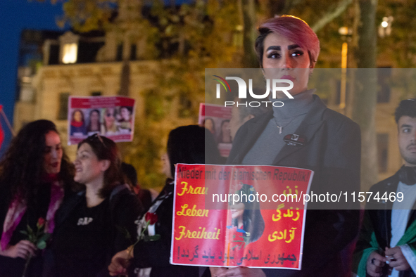 Nearly a hundred Iranian activists take part in a candlelight vigil for the second anniversary of Mahsa Amini's death in Cologne, Germany, o...