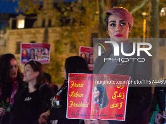 Nearly a hundred Iranian activists take part in a candlelight vigil for the second anniversary of Mahsa Amini's death in Cologne, Germany, o...