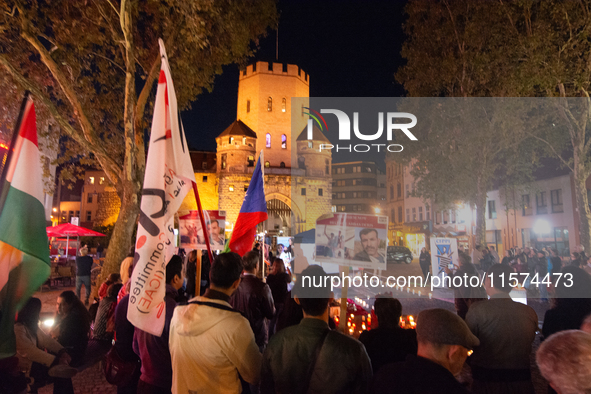 Nearly a hundred Iranian activists take part in a candlelight vigil for the second anniversary of Mahsa Amini's death in Cologne, Germany, o...