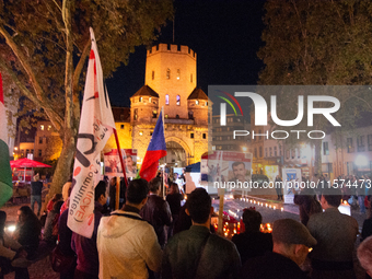 Nearly a hundred Iranian activists take part in a candlelight vigil for the second anniversary of Mahsa Amini's death in Cologne, Germany, o...