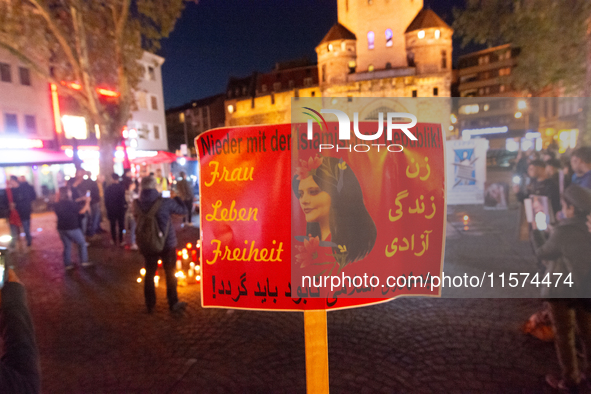 Nearly a hundred Iranian activists take part in a candlelight vigil for the second anniversary of Mahsa Amini's death in Cologne, Germany, o...