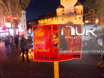 Nearly a hundred Iranian activists take part in a candlelight vigil for the second anniversary of Mahsa Amini's death in Cologne, Germany, o...