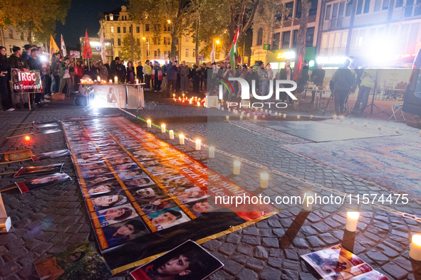 Nearly a hundred Iranian activists take part in a candlelight vigil for the second anniversary of Mahsa Amini's death in Cologne, Germany, o...