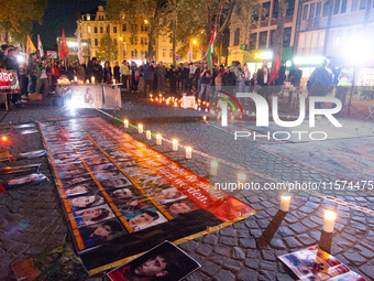 Nearly a hundred Iranian activists take part in a candlelight vigil for the second anniversary of Mahsa Amini's death in Cologne, Germany, o...