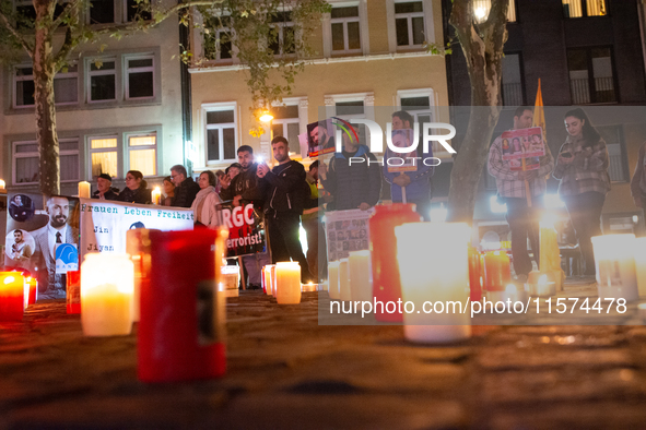 Nearly a hundred Iranian activists take part in a candlelight vigil for the second anniversary of Mahsa Amini's death in Cologne, Germany, o...