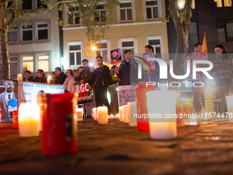 Nearly a hundred Iranian activists take part in a candlelight vigil for the second anniversary of Mahsa Amini's death in Cologne, Germany, o...