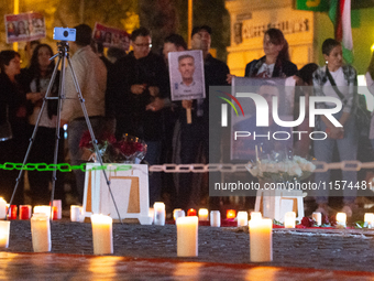 Nearly a hundred Iranian activists take part in a candlelight vigil for the second anniversary of Mahsa Amini's death in Cologne, Germany, o...