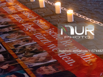 Nearly a hundred Iranian activists take part in a candlelight vigil for the second anniversary of Mahsa Amini's death in Cologne, Germany, o...