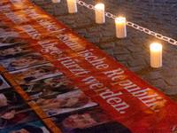 Nearly a hundred Iranian activists take part in a candlelight vigil for the second anniversary of Mahsa Amini's death in Cologne, Germany, o...