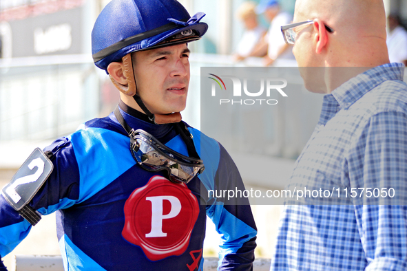 Jockey Eswan Flores speaks to a race connection after the fourth race at Woodbine Racetrack in Toronto, Canada, on September 14, 2024. 