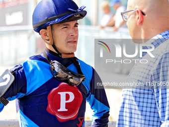 Jockey Eswan Flores speaks to a race connection after the fourth race at Woodbine Racetrack in Toronto, Canada, on September 14, 2024. (