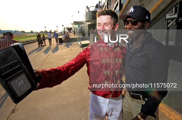 Jockey Oisin Murphy helps a race fan take a photograph after a win in the bet365 Summer Stakes (Grade I) at Woodbine Racetrack in Toronto, C...