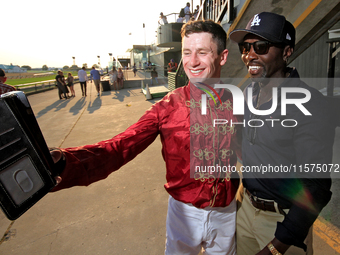 Jockey Oisin Murphy helps a race fan take a photograph after a win in the bet365 Summer Stakes (Grade I) at Woodbine Racetrack in Toronto, C...