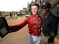 Jockey Oisin Murphy helps a race fan take a photograph after a win in the bet365 Summer Stakes (Grade I) at Woodbine Racetrack in Toronto, C...