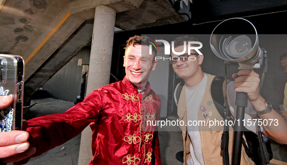 Jockey Oisin Murphy helps a race fan take a photograph after a win in the bet365 Summer Stakes (Grade I) at Woodbine Racetrack in Toronto, C...