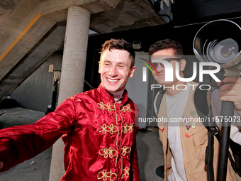 Jockey Oisin Murphy helps a race fan take a photograph after a win in the bet365 Summer Stakes (Grade I) at Woodbine Racetrack in Toronto, C...