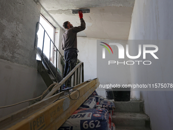 A construction worker restores a multi-storey residential building damaged by Russian shelling in Kharkiv, Ukraine, on September 12, 2024. N...