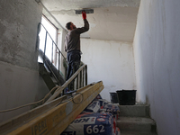 A construction worker restores a multi-storey residential building damaged by Russian shelling in Kharkiv, Ukraine, on September 12, 2024. N...