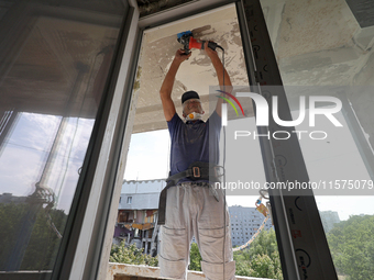 A construction worker restores a multi-storey residential building damaged by Russian shelling in Kharkiv, Ukraine, on September 12, 2024. N...