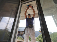 A construction worker restores a multi-storey residential building damaged by Russian shelling in Kharkiv, Ukraine, on September 12, 2024. N...